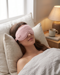 Woman reclining comfortably while wearing the pink eye mask