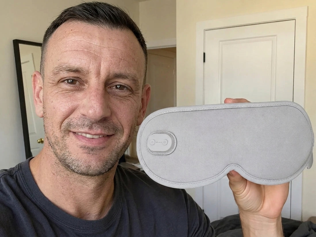 Man holding the grey heated eye mask in a bedroom